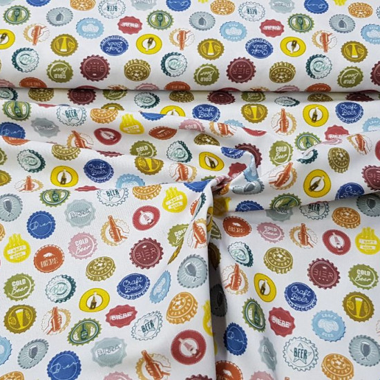Cotton Beer Badges fabric - Organic cotton fabric with pictures of colorful beer bottle caps on a white background. The fabric is 150cm wide and its composition is 100% cotton.