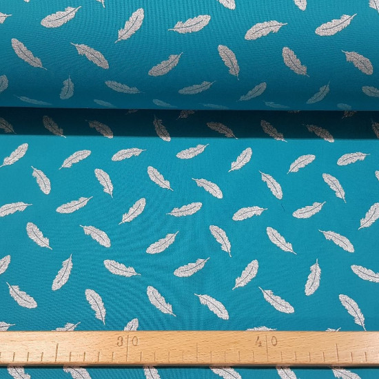 Cotton Feathers Silver Turquoise fabric - Cotton fabric with feather patterns in silver foil effect, on a turquoise background. The fabric is 150cm wide and its composition is 100% cotton.