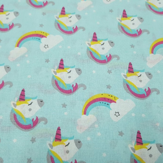 Tela Algodón Unicornios Nubes Arcoiris - Preciosa tela de algodón infantil de temática unicornios y nubes con arcoiris sobre un fondo azul suave. La tela mide 150cm de ancho y su composición 100% algodón