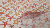 Tela Algodón Estrellas de Mar - Tela de algodón ancho americano con dibujos de estrellas de mar sobre un fondo claro. La tela mide 110cm de ancho y su composición 100% algodón.