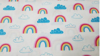 Tela Algodón Arcoiris Nubes - Tela de algodón ancho americano con dibujos de arcoiris y nubes en tonos azules sobre un fondo blanco. La tela mide 110cm de ancho y su composición 100% algodón.