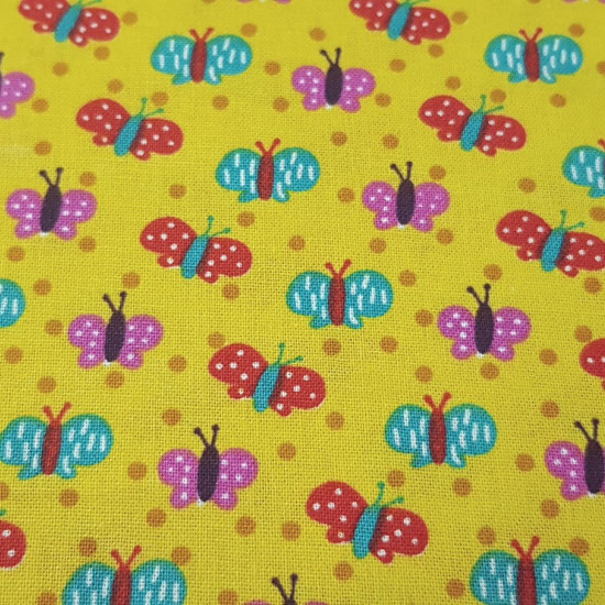 Cotton Butterflies Mustard Colors fabric - Cotton fabric with drawings of colored butterflies on a mustard yellow background. This fabric is part of The Craft Cotton Company's Happy Owls collection. The fabric is 110cm wide and its composition is 100%