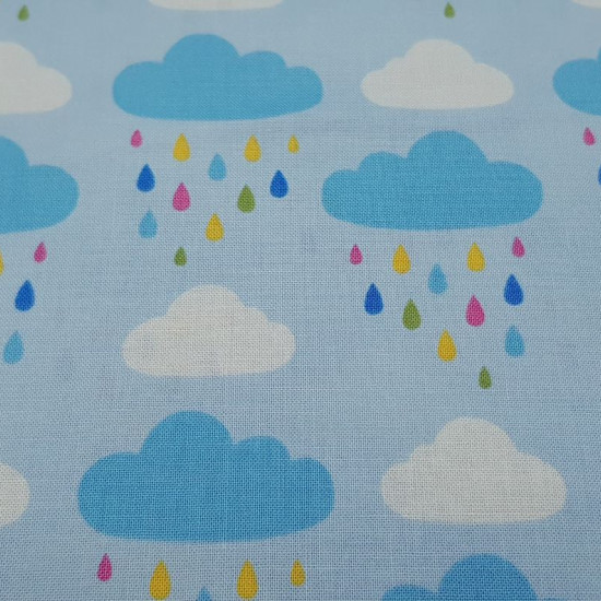 Cotton Clouds Rain Colors fabric - Cotton fabric with drawings of white and blue clouds with multicolored rain drops on a light blue background. The fabric is 110cm wide and its composition is 100% cotton.