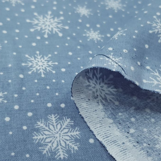 Cotton Christmas Forest Snowflakes fabric - Christmas cotton fabric with drawings of snowflakes on a background with white polka dots simulating snow. The fabric is 110cm wide and its composition is 100% cotton.
