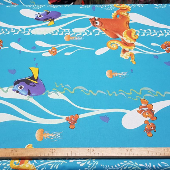 Cotton Disney Finding Dory fabric - Decorative Disney license cotton fabric with large drawings of the characters from the movie Finding Dory, where Nemo, Marlin, Dory and Hunk appear on a blue ocean background. The fabric is 140cm wide and its composi