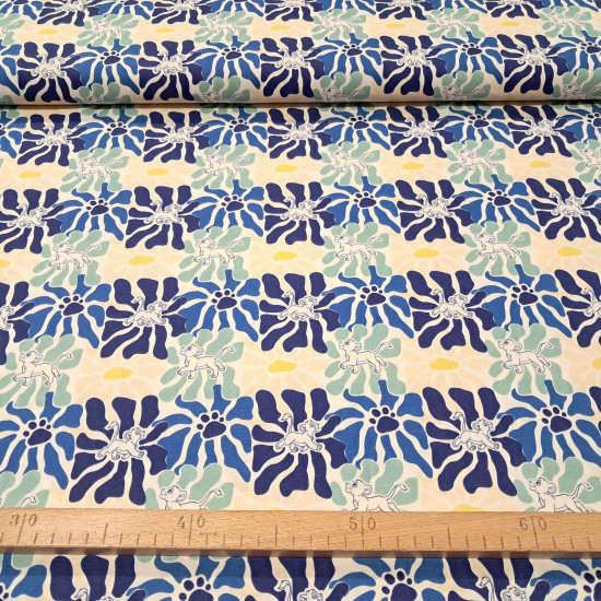 Cream cotton poplin fabric with a graphic pattern of large flowers in blue, mint green, and footprints with the silhouette of Simba from The Lion King.