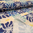 Cream cotton poplin fabric with a graphic pattern of large flowers in blue, mint green, and footprints with the silhouette of Simba from The Lion King.