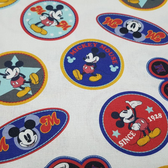 Tela Algodón Disney Mickey Parches - Tela de algodón licencia Disney con dibujos del personaje Mickey en parches de formas circulares y ovaladas sobre un fondo blanco. La tela mide 150cm de ancho y su composición 100% algodón.