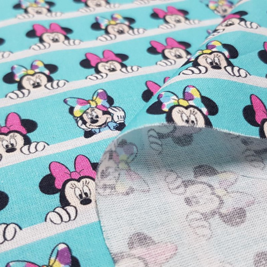 Cotton Disney Minnie Looks Out fabric - Disney licensed cotton fabric with drawings of the character Minnie looming over white lines, on a contrasting turquoise blue background. The fabric is 150cm wide and its composition is 100% cotton.
