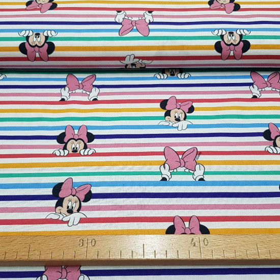 Tela Algodón Disney Minnie Asomada Arcoiris - Tela de algodón licencia Disney con dibujos del personaje Minnie asomada sobre arcoiris de rayas anchas donde también aparecen lazos rosas. La tela mide 150cm de ancho y su composición 100% algodón.