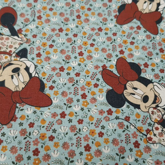 Cotton Disney Minnie Flowers Blue fabric - Children's cotton fabric with drawings of Disney's Minnie character on a flowered background where the light blue color predominates. The fabric is 140cm wide and its composition 100% cotton.