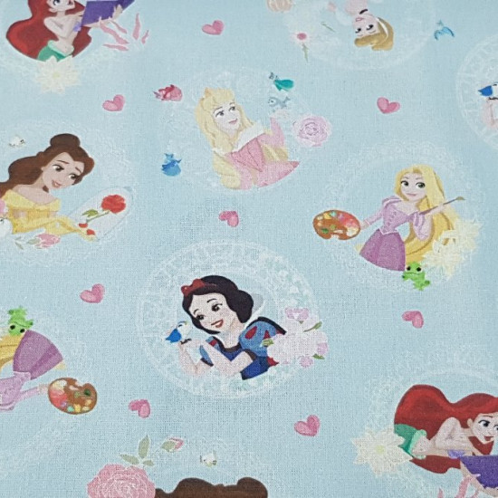 Cotton Disney Princesses Blue fabric - Disney cotton fabric with the drawings of princesses like Ariel, Rapuntzel, Bella, Snow White, Cinderella and Aurora on a light blue background with hearts.