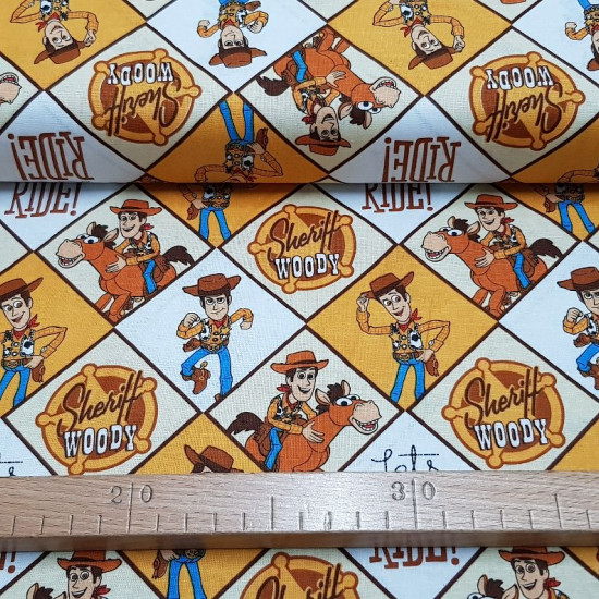 Cotton Toy Story Woody fabric - Disney licensed cotton fabric with the character Woody, the cowboy from the movie Toy Story, who appears in several panels on his Bullseye horse. The fabric is 110cm wide and its composition is 100% cotton.
