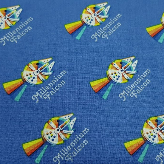 Cotton Star Wars Rainbow Millennium Falcon fabric - Licensed cotton fabric with drawings of the Millennium Falcon from Star Wars in “rainbow” style leaving a multicolored trail on a blue background where texts also appear: “Millennium Falcon”. The fabric 