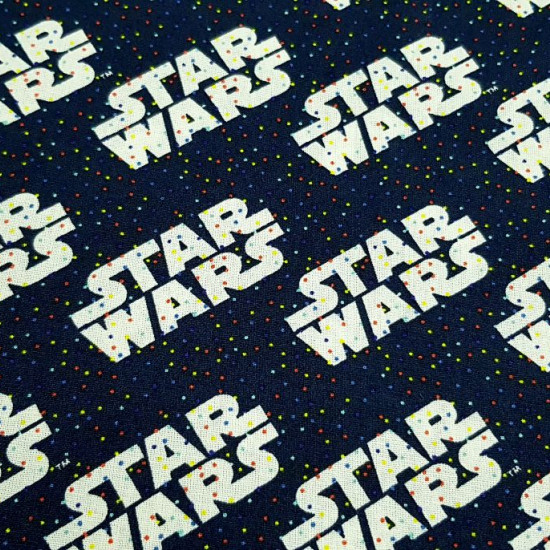 Tela Algodón Star Wars Rainbow Logos - Tela de algodón ancho americano licencia Star Wars donde aparecen logotipos sobre un fondo azul marino con diminutos topitos multicolor. La tela mide 110cm de ancho y su composición 100% algodón.