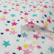 Tela Algodón Estrellas Colores - Tela de algodón con dibujos de estrellas de colores y varios tamaños sobre un fondo blanco. La tela mide 150cm de ancho y su composición 100% algodón.