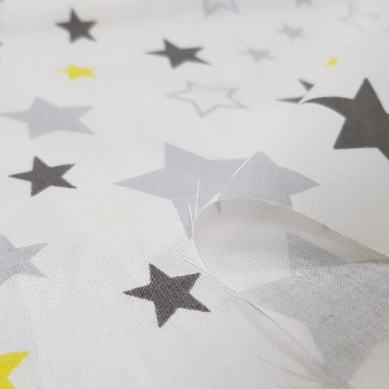 Tela Algodón Estrellas Decorativas - Tela de algodón con dibujos decorativos de estrellas de colores grises y amarillo sobre un fondo blanco. La tela mide 160cm de ancho y su composición 100% algodón.