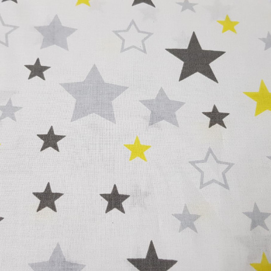 Tela Algodón Estrellas Decorativas - Tela de algodón con dibujos decorativos de estrellas de colores grises y amarillo sobre un fondo blanco. La tela mide 160cm de ancho y su composición 100% algodón.