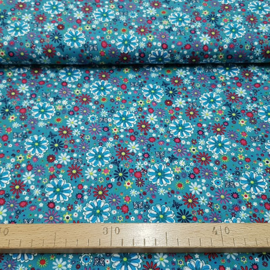 Cotton Flowers Colors Butterflies fabric - Cotton fabric with drawings of flowers of various sizes and colors on petrol blue background with butterflies. The fabric is 140cm wide and its composition is 100% cotton.