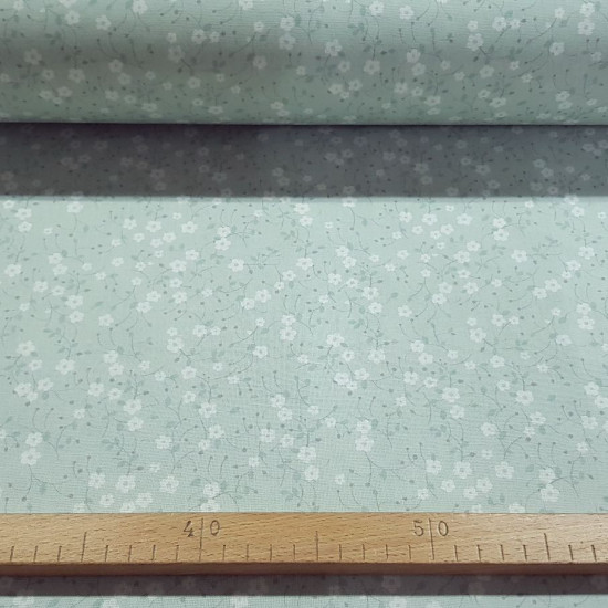 Cotton Little Flowers Mint fabric - Cotton poplin fabric with small white flower patterns on a mint green background. The fabric is 150cm wide and its composition is 100% cotton.