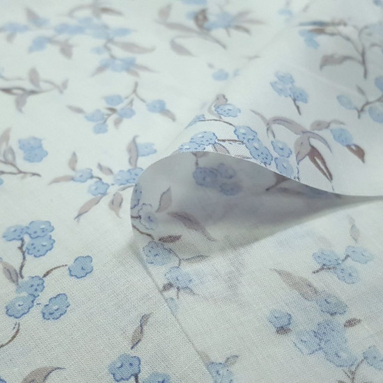 Cotton Voile Blue Flowers fabric - Fine and light batiste / voile cotton fabric with blue flower patterns on a white background. The fabric is 150cm wide and its composition is 100% cotton.