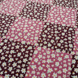 Algodón Flores Margaritas Kala - Tela de popelín algodón con dibujos de flores pequeñas con forma de margarita sobre un fondo formando cuadrículas estilo patchwork en tonos lilas. La tela mide 150cm de ancho y su composic