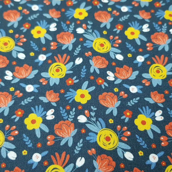 Cotton Flowers Flua Blue fabric - Organic cotton fabric with drawings of various colored flowers on a blue background. The fabric is 150cm wide and its composition is 100% cotton.
