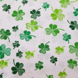 Cotton Green Clover fabric - Poplin cotton fabric with green four-leaf clover patterns on a white background. The fabric is 160cm wide and its composition is 100% cotton.