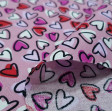Tela Algodón Corazones Allover Rosa - Tela de algodón con dibujos de corazones pequeños de varios colores sobre un fondo de color rosa. La tela mide 150cm de ancho y su composición 100% algodón.