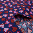 Tela Algodón Corazones Allover Marino - Tela de algodón con dibujos de corazones pequeños en varios colores de tonos rojos y rosas sobre un fondo azul marino. La tela mide 150cm de ancho y su composición 100% algodón.
