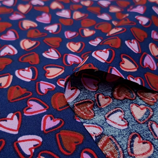 Tela Algodón Corazones Allover Marino - Tela de algodón con dibujos de corazones pequeños en varios colores de tonos rojos y rosas sobre un fondo azul marino. La tela mide 150cm de ancho y su composición 100% algodón.