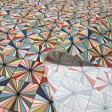 Cotton Mosaic Ornamental Geometric fabric - Cotton poplin fabric with geometric patterns forming an ornamental mosaic of multicolored triangles. The fabric is 150 cm wide and is made of 100% cotton.