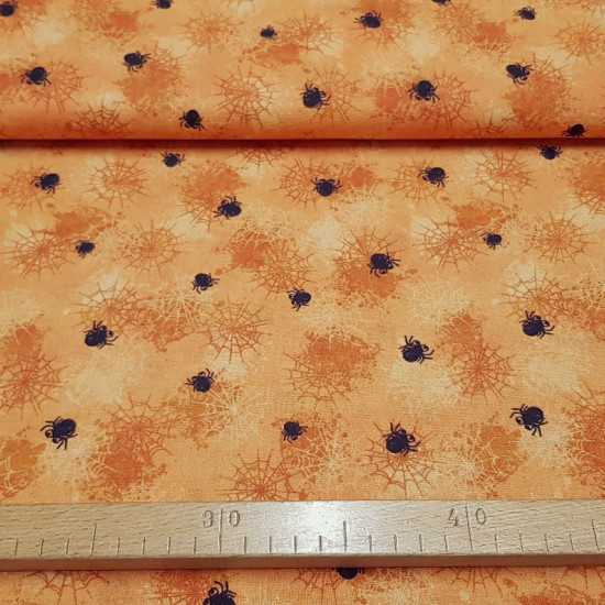 Cotton Halloween Cobwebs Orange Background fabric - Cotton fabric with drawings of spider webs and spiders of various sizes on an orange background. The fabric is 150cm wide and its composition 100% cotton.