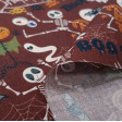 Cotton Halloween Boo to you fabric - Halloween themed cotton fabric with drawings of dancing skeletons, scarecrows with pumpkin heads, bats and the letters “Happy Halloween” and “Boo to you”... on a maroon-brown background. The fabric is 150cm wide and