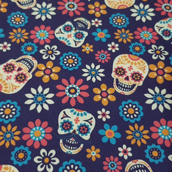 Cotton Floral Skulls Violet fabric - Digitally printed cotton fabric with colorful floral skull drawings on a dark purple background. The fabric is 140cm wide and its composition 100% cotton