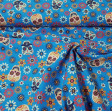 Tela Algodón Calaveras Florales Azul - Tela de algodón impresión digital con dibujos de calaveras floreadas con mucho color sobre un fondo de color azul. La tela mide 140cm de ancho y su composición 100% algodón.