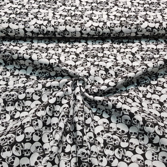Tela Algodón Calaveras Terroríficas - Tela de algodón popelín con dibujos de calaveras terroríficas de varios tamaños sobre un fondo negro. La tela mide 150cm de ancho y su composición 100% algodón.