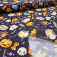 Cotton Halloween Boo Spooky fabric - Halloween-themed cotton poplin fabric with drawings of ghosts, pumpkins, spiders, bats, candy, and more on a violet background. The fabric is 150 cm wide and is made of 100% cotton.