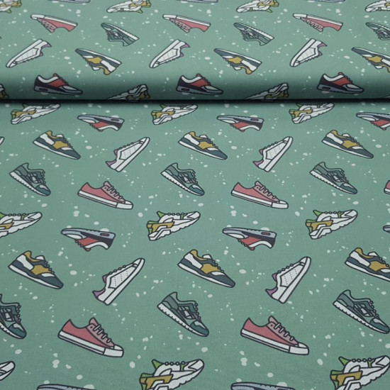 Cotton Girls Sports Shoes fabric - Organic cotton poplin fabric with drawings of various models of running sneakers on a mint green background with white splashes. The fabric is 150cm wide and its composition is 100% cotton.