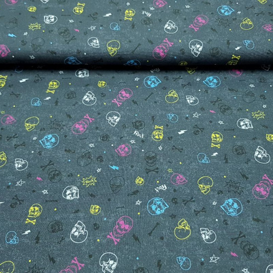 Cotton Rock Skulls fabric - Cotton fabric with drawings of various colored skulls on a dark gray background with Rock letters, multi-colored rays and bones. The fabric is 150cm wide and its composition is 100% cotton.