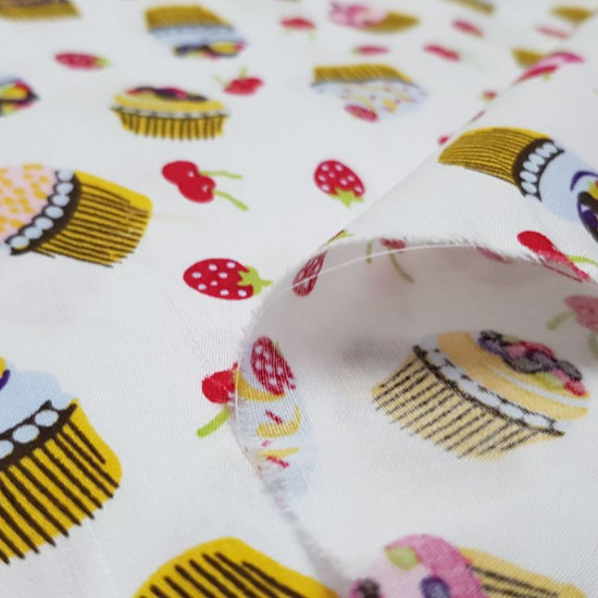 Cotton Cupcakes Fruits fabric - Cotton fabric with drawings of cupcakes and red fruits, cherries and strawberries, on a white background The fabric is 150cm wide and its composition is 100% cotton.