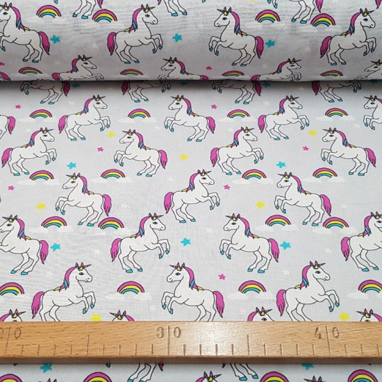 Tela Algodón Unicornios Estrellas Gris - Tela de algodón infantil impresión digital con dibujos de unicornios, estrellas y arcoiris sobre un fondo gris. La tela mide 145cm de ancho y su composición 100% algodón.