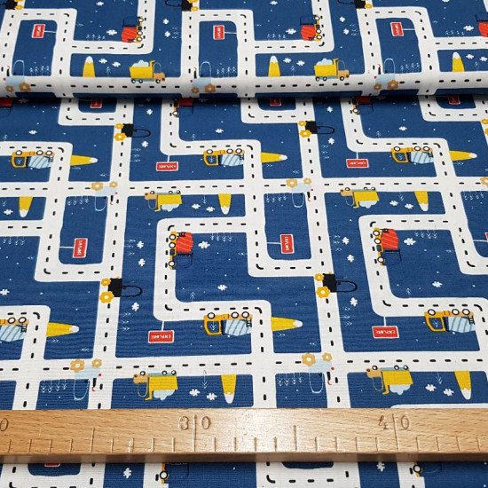 Tela Algodón Transportes Azul - Tela de algodón infantil con dibujos de camiones de transporte en carreteras sobre un fondo azul. La tela mide 150cm de ancho y su composición 100% algodón.