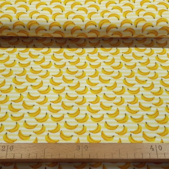 Tela Algodón Plátanos Rayas - Tela de algodón con dibujos de plátanos sobre un fondo de rayas amarillas. La tela mide 150cm de ancho y su composición 100% algodón.