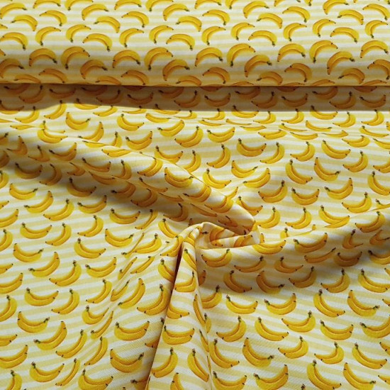 Cotton Striped Bananas fabric - Cotton fabric with drawings of bananas on a yellow striped background. The fabric is 150cm wide and its composition is 100% cotton.