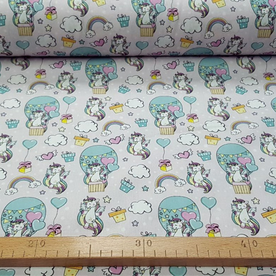 Cotton Unicorns Rainbow Hair fabric - Children's cotton fabric with drawings of unicorns with colored hair, clouds, balloons, rainbows, colored stars on a light background. The fabric is 140cm wide and its composition is 100% cotton.