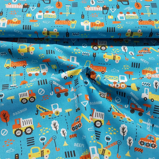 Tela Algodón Transportes Naranja Amarillo - Tela de algodón con dibujos de transportes, coches, camiones, gruas en tonos naranja y amarillo sobre un fondo de color azul. La tela mide 150cm de ancho y su composición 100% algodón.