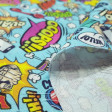Cotton Comic Style Blue fabric - Cotton fabric with onomatopoeia drawings written in striking comic-style speech bubbles, on a blue background. The fabric is 150cm wide and its composition is 100% cotton.