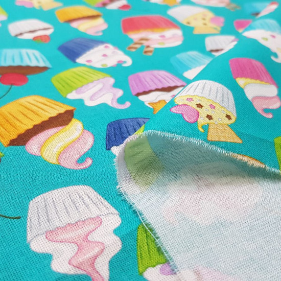 Cotton Cupcakes Multicolor fabric - Poplin cotton fabric with colorful cupcake drawings on a turquoise green background. The fabric is 150cm wide and its composition is 100% cotton.