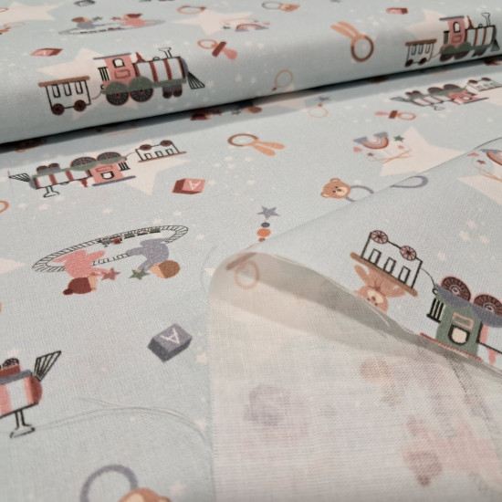 Cotton Trains Babies fabric - Cotton poplin fabric with drawings of toy trains, pacifiers, teethers, baby crib mobiles, babies... on a light colored background with white stars. The fabric measures 150cm wide and its composition is 100% cotton.